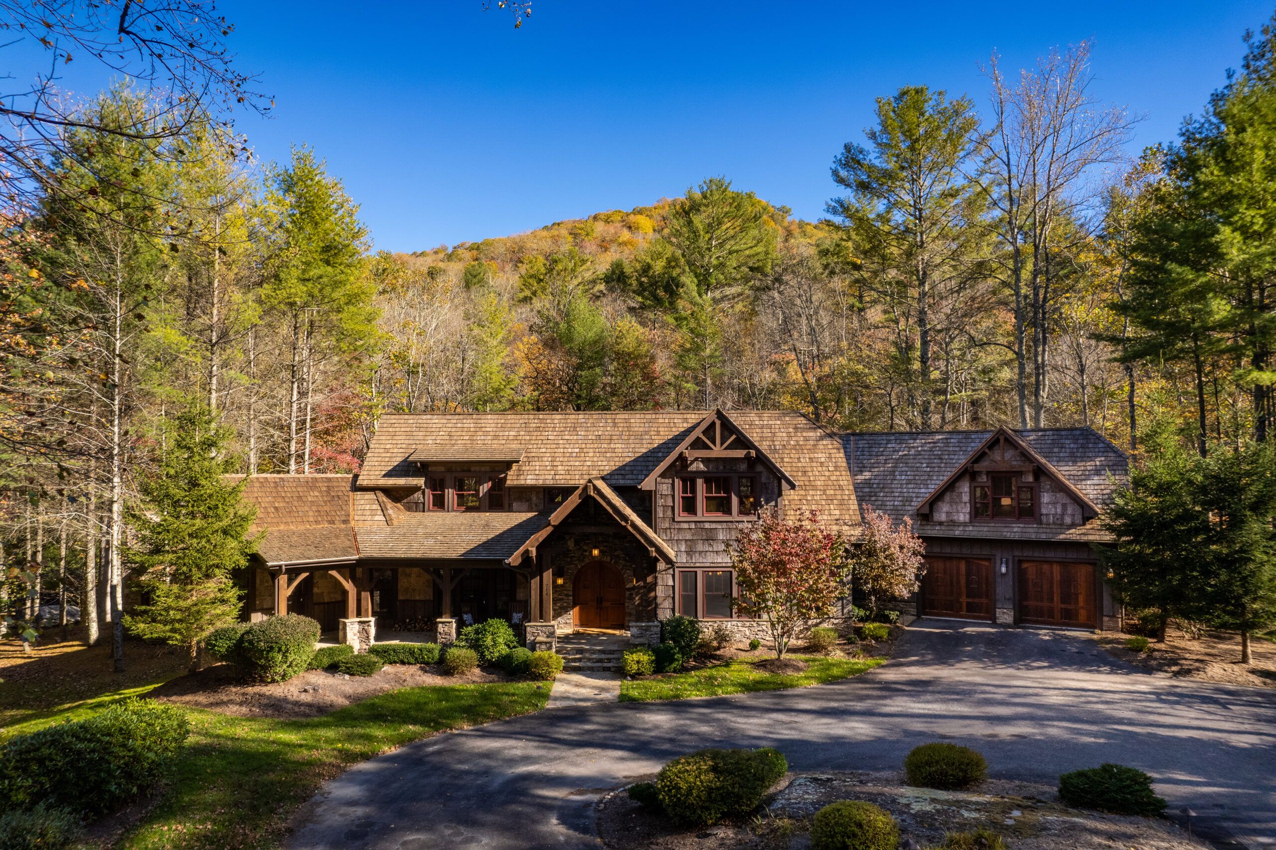 Cottage in the woods with trees and paved compound